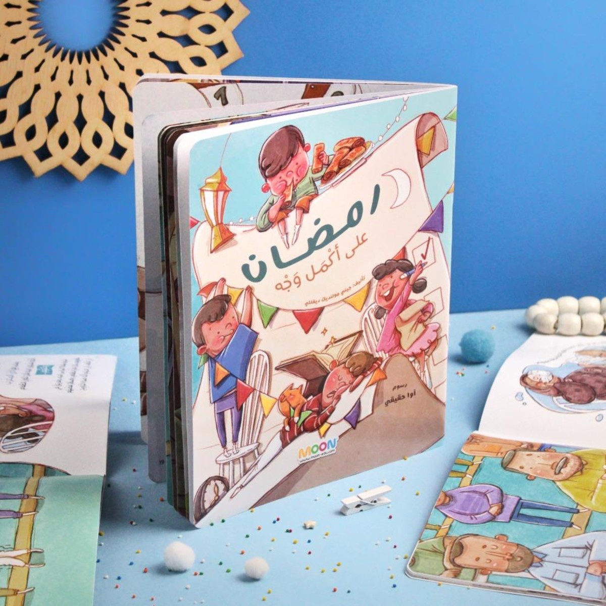 غلاف قصة الأطفال "رمضان على أكمل وجه" من إصدارات MOON، يظهر أطفالاً يحتفلون بزينة رمضان وأجواء العبادة والبهجة، لتعليم الصغار آداب الشهر الفضيل.